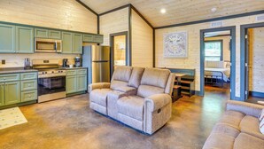 Ein gemütliches Blockhaus-Interieur mit einer Küchenzeile, einer Couch und einem Essbereich.