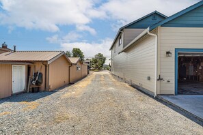 A narrow gravel driveway leading to a row of single-story buildings with attached garages.