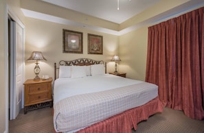 A hotel room with a large bed, two bedside lamps, a wooden nightstand, a telephone, and two framed pictures on the wall. - Disney dreams apartment Amazing lake views! (Orlando)