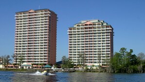 Two high-rise hotels with multiple floors, waterfront views, and a boat on the water. - Disney dreams Penthouse water view Mall restaurant (Orlando)