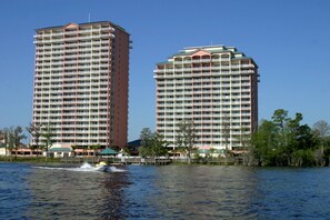 Zwei hohe Hotels mit vielen Stockwerken, Blick auf das Wasser und ein Boot auf dem Wasser.