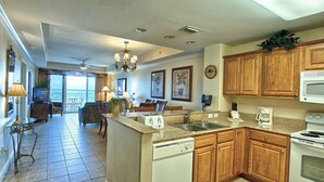 A spacious kitchen with wooden cabinets, a microwave, a stove, and a dishwasher. - Disney dreams Penthouse water view Mall restaurant (Orlando)