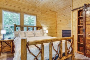 A wooden cabin bedroom with a bed, nightstands, and a dresser. - Cabin Retreat w/ Hot Tub Near Downtown Helen! (Helen)