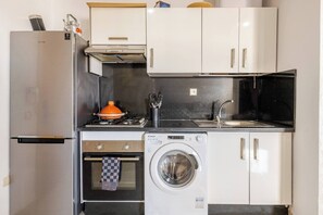 A compact kitchen with a refrigerator, oven, washing machine, sink, and cabinets. - Beautiful apartment in Mansbay Beach next to the beach (Mansouria)