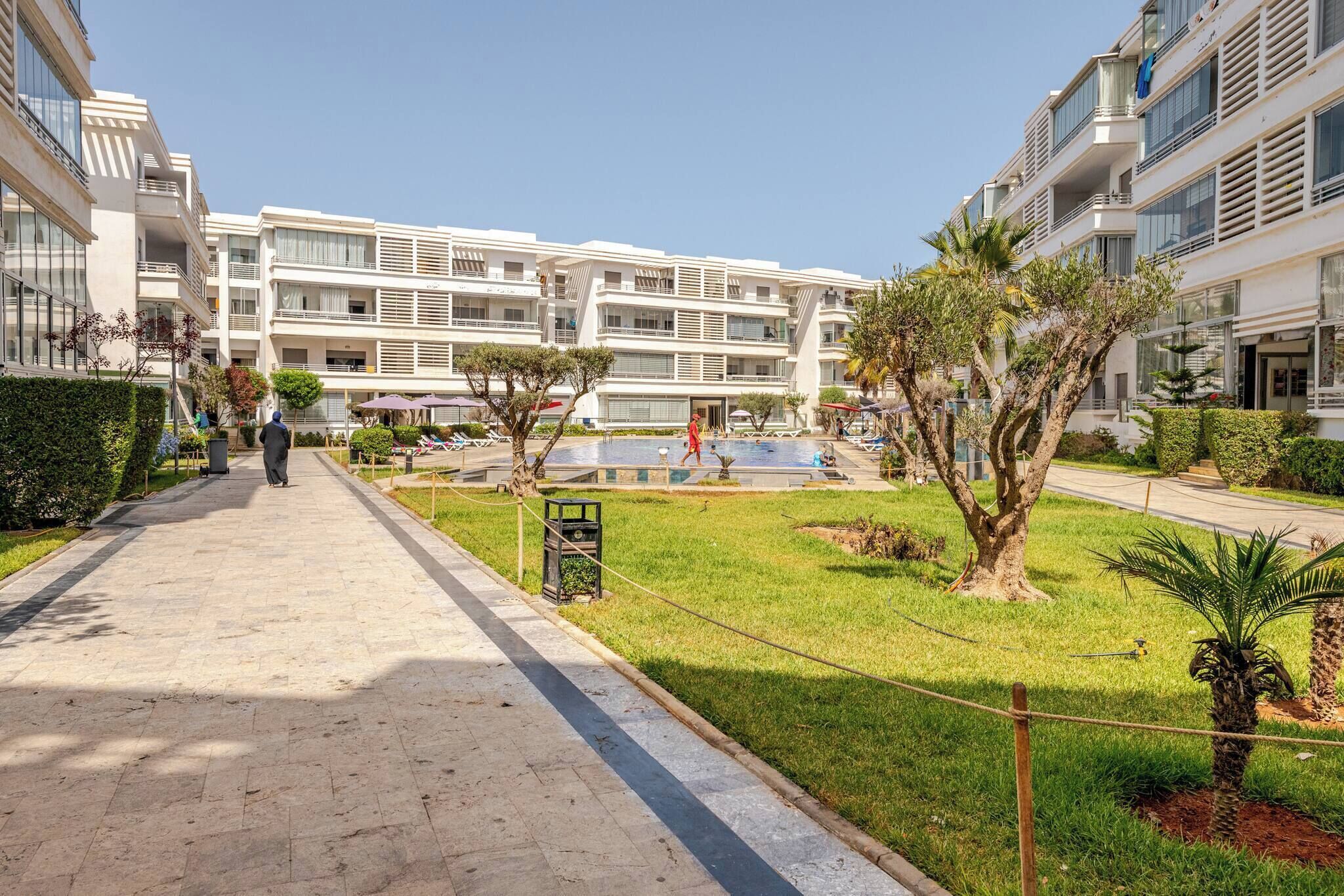 Een modern hotel met een centrale binnenplaats, een zwembad en een verzorgde tuin.