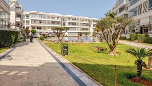 Un hotel modern amb un pati central, una piscina i un jardí ben cuidat.