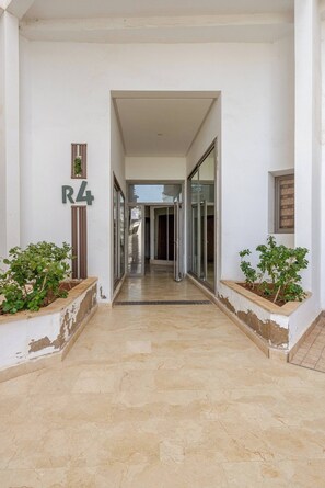 A corridor with a marble floor leading to a glass door entrance. - Beautiful apartment in Mansbay Beach next to the beach (Mansouria)