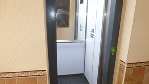 An elevator interior with a tiled floor, a handrail, and a door with a number 4 sign. - 1 bedroom apartment at 50 meters from the beach (Roquetas de Mar)