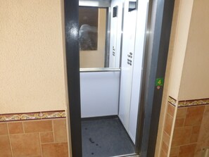 An elevator interior with a tiled floor, a handrail, and a door with a number 4 sign. - 1 bedroom apartment at 50 meters from the beach (Roquetas de Mar)