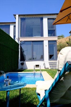 A modern house with a swimming pool, a barbecue grill, and a chair under an umbrella. - 4-Deluxe Villa with Heated Private Pool (Dilovası)