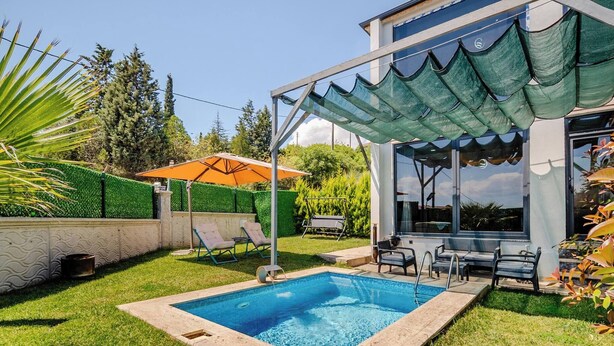Un patio trasero con piscina, mobiliario exterior y un porche cubierto.