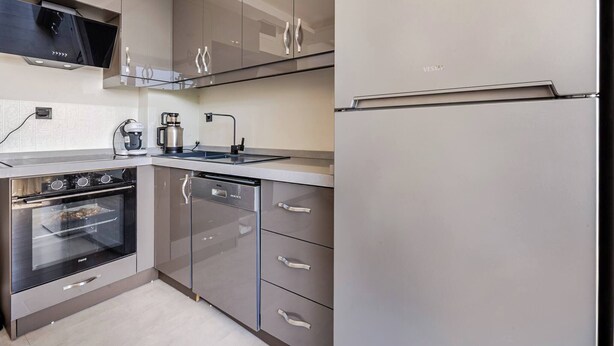 A modern kitchen with stainless steel appliances, a built-in oven, and a refrigerator. - 2 Superior Villa Isıtmalı Havuz ve Deniz Manzara (Dilovası)