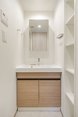 A bathroom with a white vanity, a mirror, and a shower. - MoriKoYa Hotel · 2BR Deluxe 45m² · Senso-ji 5 min (Taito City)