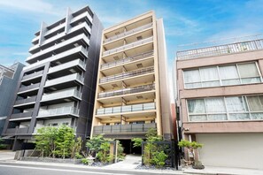 A multi-story residential building with balconies, a gated entrance, and a parking garage. - MoriKoYa Hotel · 2BR Deluxe 45m² · Senso-ji 5 min (Taito City)