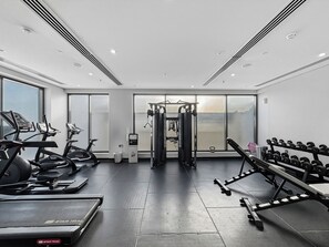 Una palestra con tapis roulant, panche per pesi e manubri.