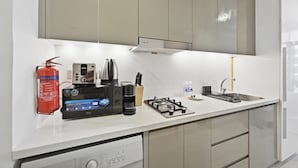 Ett modernt kök med inbyggd diskmaskin, gasspis och kaffebryggare.