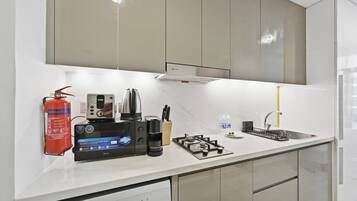 Uma cozinha moderna com máquina de lavar louça embutida, fogão a gás e cafeteira.