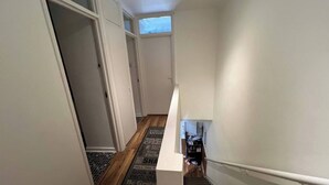 En smal gang med trægulv og et tæppe med motiverende citater.