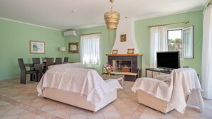 Ein Hotelzimmer mit zwei Betten, einem Fernseher, einem Kamin und einer Essecke.