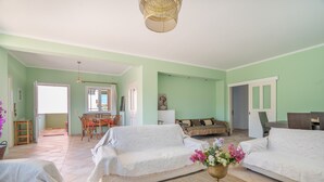 Ein geräumiges Wohnzimmer mit einer Sofagarnitur, einem Essbereich und Blick ins Freie.