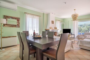 A dining area with a table, chairs, and a television. - Agis Luxury House Apartment with Sea View, Wi-Fi, and Air Conditioning (Lefkada)