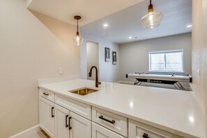 A kitchen with a white countertop, a stainless steel sink, and a window with blinds. - Great for Families! Arvada Haven w/ Yard & Patio (Arvada)