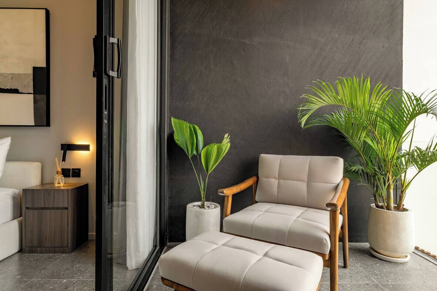 A modern living room with a sofa, a chair, and two potted plants.