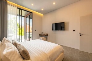 Une chambre moderne avec un grand lit, un téléviseur fixé au mur et une porte-fenêtre coulissante donnant sur un espace extérieur.
