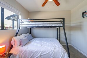 A bunk bed with white bedding, a ceiling fan, a window with blinds, and a lamp on a bedside table. - Desert Retreat w/ Pool Near Dtwn Tempe & ASU (Tempe)