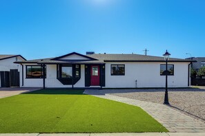 A single-story house with a red door, a small front yard with artificial grass, and a street lamp. - Desert Retreat w/ Pool Near Dtwn Tempe & ASU (Tempe)
