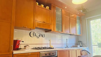 Una cocina con armarios de madera, una estufa a gas, un horno y un salpicadero con la palabra "Cuisinart".