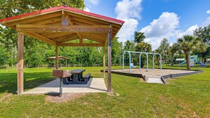 A park with a wooden pavilion, picnic tables, and playground equipment. - On Deer Point Lake! Home w/ Private Dock & Hot Tub (Youngstown)