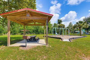 A park with a wooden pavilion, picnic tables, and playground equipment. - On Deer Point Lake! Home w/ Private Dock & Hot Tub (Youngstown)