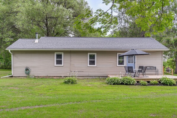A single-story house with a front porch, a chimney, and a small deck with outdoor furniture. - Creekside Retreat in Speedsville w/ Deck & Yard (Berkshire)