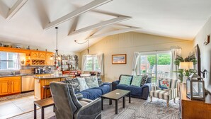 A spacious living area with a sofa, armchairs, and a coffee table. There is a kitchen area with wooden cabinets and a dining table. - 1 1/2 Blocks to Beach! Close to A/C, Casinos (Brigantine)