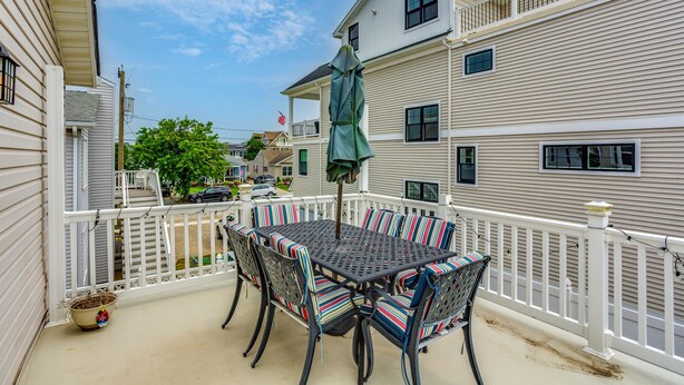 A balcony with a table and chairs, a potted plant, and a view of neighboring houses. - 1 1/2 Blocks to Beach! Close to A/C, Casinos (Brigantine)