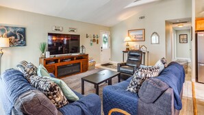 A living room with a television, seating, and a door leading to another room. - 1 1/2 Blocks to Beach! Close to A/C, Casinos (Brigantine)