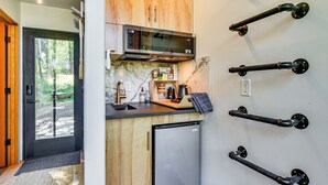 Una cocina funcional con microondas, refrigerador y armarios de madera.