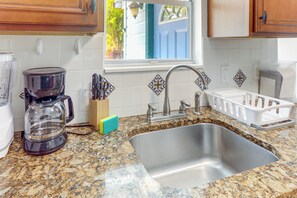 A kitchen with a granite countertop, stainless steel sink, and a coffee maker. - Walk to Lakeworth Dtwn! 5-Min Drive to Beach (Lake Worth Beach)