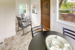 A dining area with a round table, two chairs, and a wooden door. - Walk to Lakeworth Dtwn! 5-Min Drive to Beach (Lake Worth Beach)