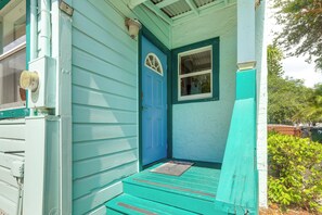 Une maison avec une porte bleue et une petite fenêtre au-dessus.