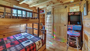 Una cabaña con literas, una kitchenette pequeña y una puerta que da a un espacio de almacenamiento.