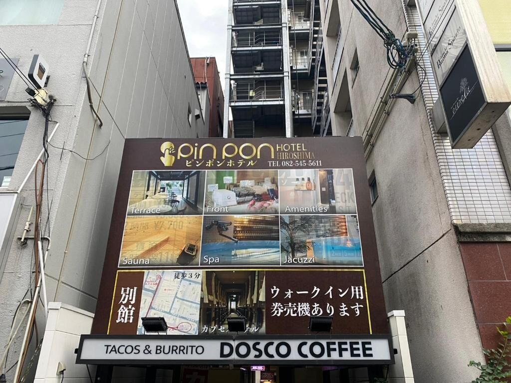 A hotel sign with amenities like terrace, front, amenities, sauna, spa, and jacuzzi. It also advertises tacos & burritos and dosco coffee.