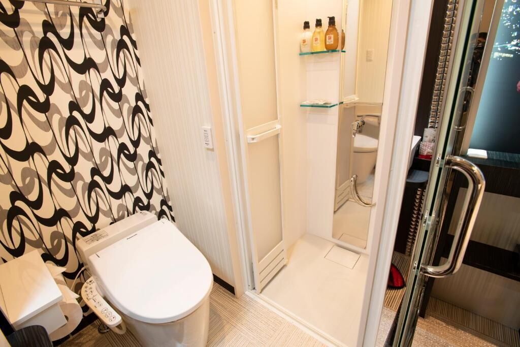 A bathroom with a toilet, a shower enclosure, and a glass shower door.
