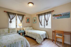 A room with two beds, a desk, and a window with curtains. - Walk to Sunset Beach! Extended Escape w/ Patio (Haleiwa)