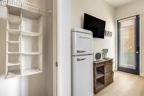 Une cuisine avec un réfrigérateur blanc, un four à micro-ondes et une machine à café, le tout posé sur un meuble en bois.