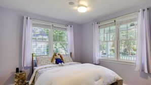 A bedroom with a bed, a window, and a stone wall. - Waterfront Gem w/ Dock: 2 Mi to Dwtn Annapolis! (Annapolis)