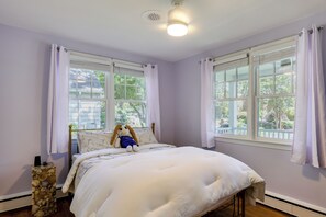 Ein Schlafzimmer mit einem Bett, einem Fenster und einer Steinwand.