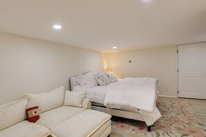 Een slaapkamer met een bed, een bank en een nachtkastje.
