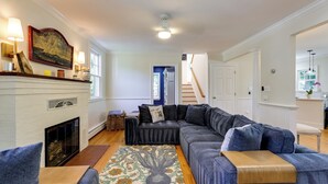 A living room with a fireplace, a sectional sofa, and a patterned rug. - Waterfront Gem w/ Dock: 2 Mi to Dwtn Annapolis! (Annapolis)